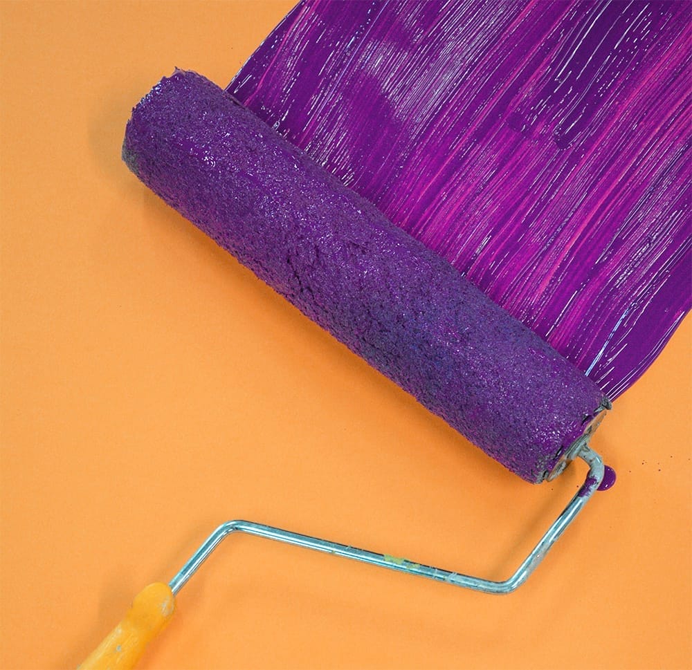 roller painting purple on wall