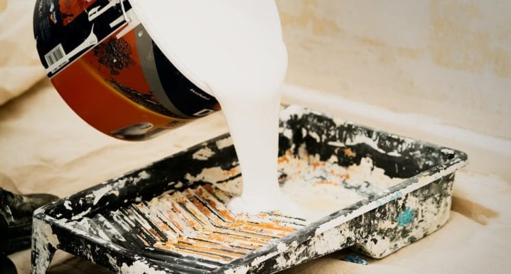 white paint being poured into a tray