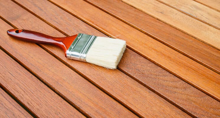 deck staining brush on wooden deck